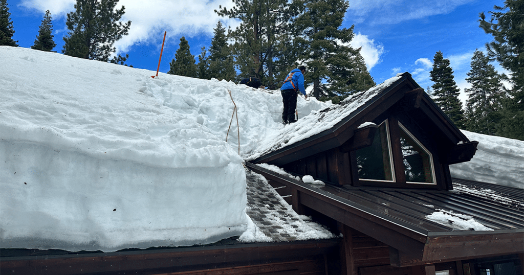 Man removing ice from roof.