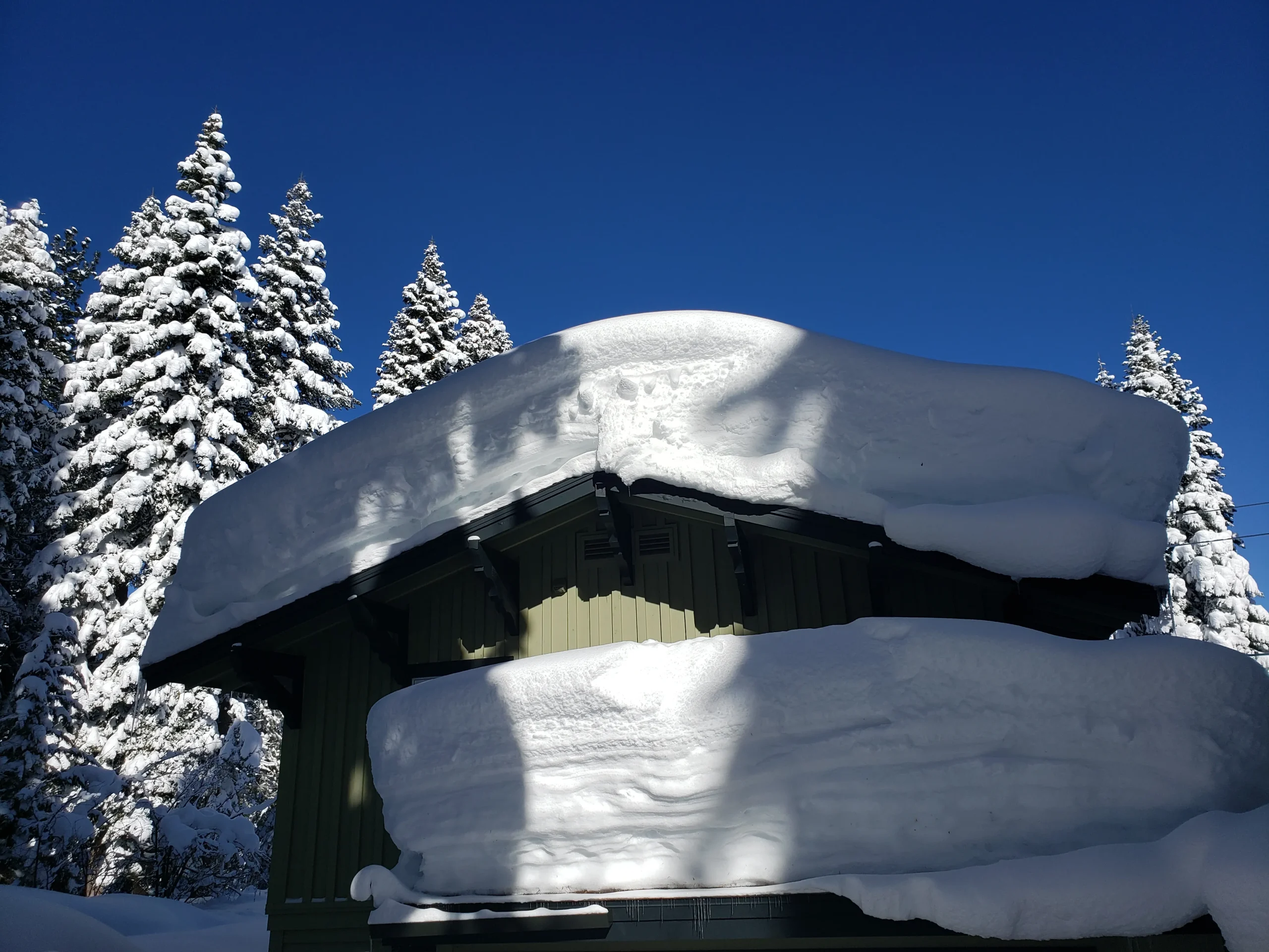 Heavy winter snow accumulation on a residential roof in Reno, Nevada, showing the need for professional snow removal and roof inspections by Mills Roofing.