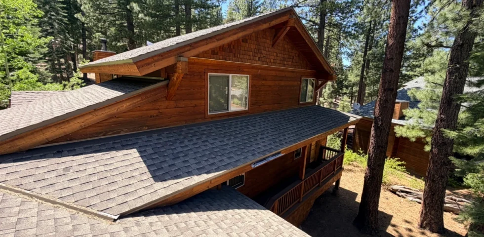 Multi-plane asphalt shingle roof on a Sierra Nevada mountain home surrounded by pine trees