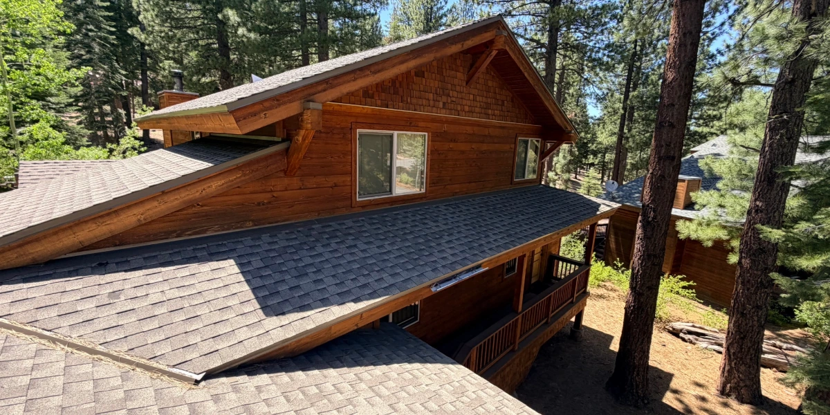 Multi-plane asphalt shingle roof on a Sierra Nevada mountain home surrounded by pine trees