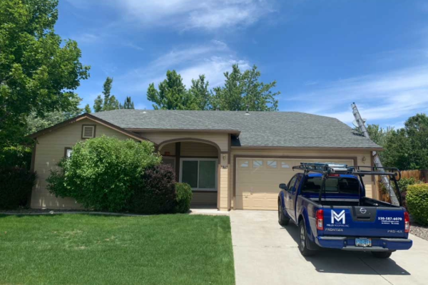 Completed residential roof replacement by Mills Roofing with company truck parked in driveway