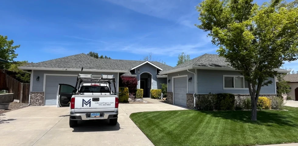 Mills Roofing truck parked in the driveway of a Reno home with a completed asphalt shingle roof replacement