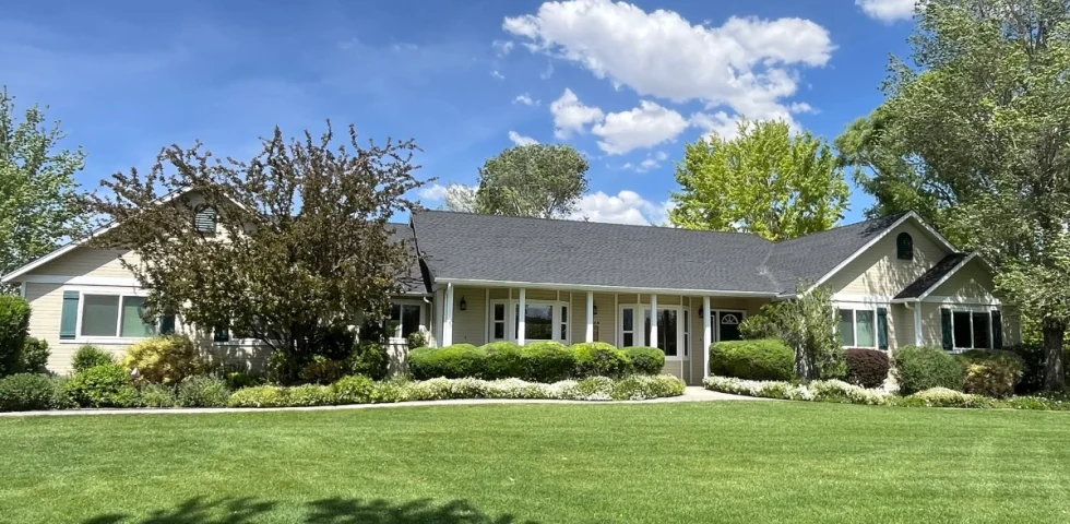 Reno area home with a completed asphalt shingle roof replacement by Mills Roofing on a sunny day