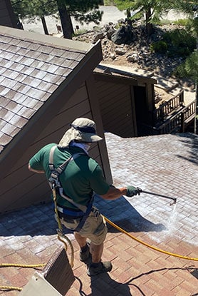 Mills Roofing employee applies Roof Maxx on commercial building
