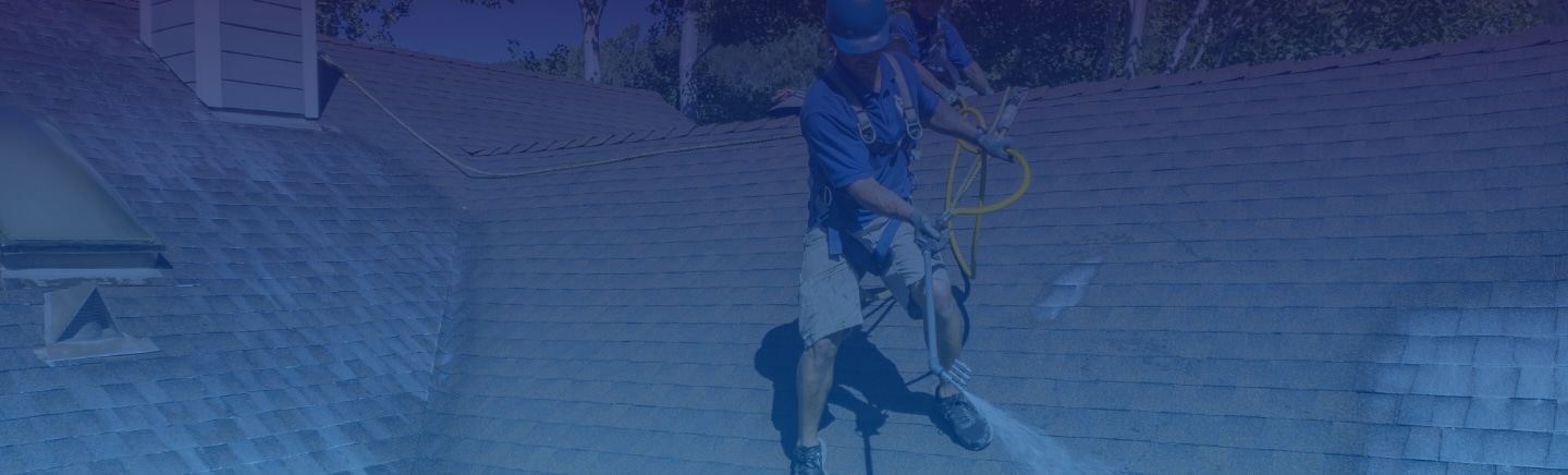Mills Roofing employee sprays Roof Maxx